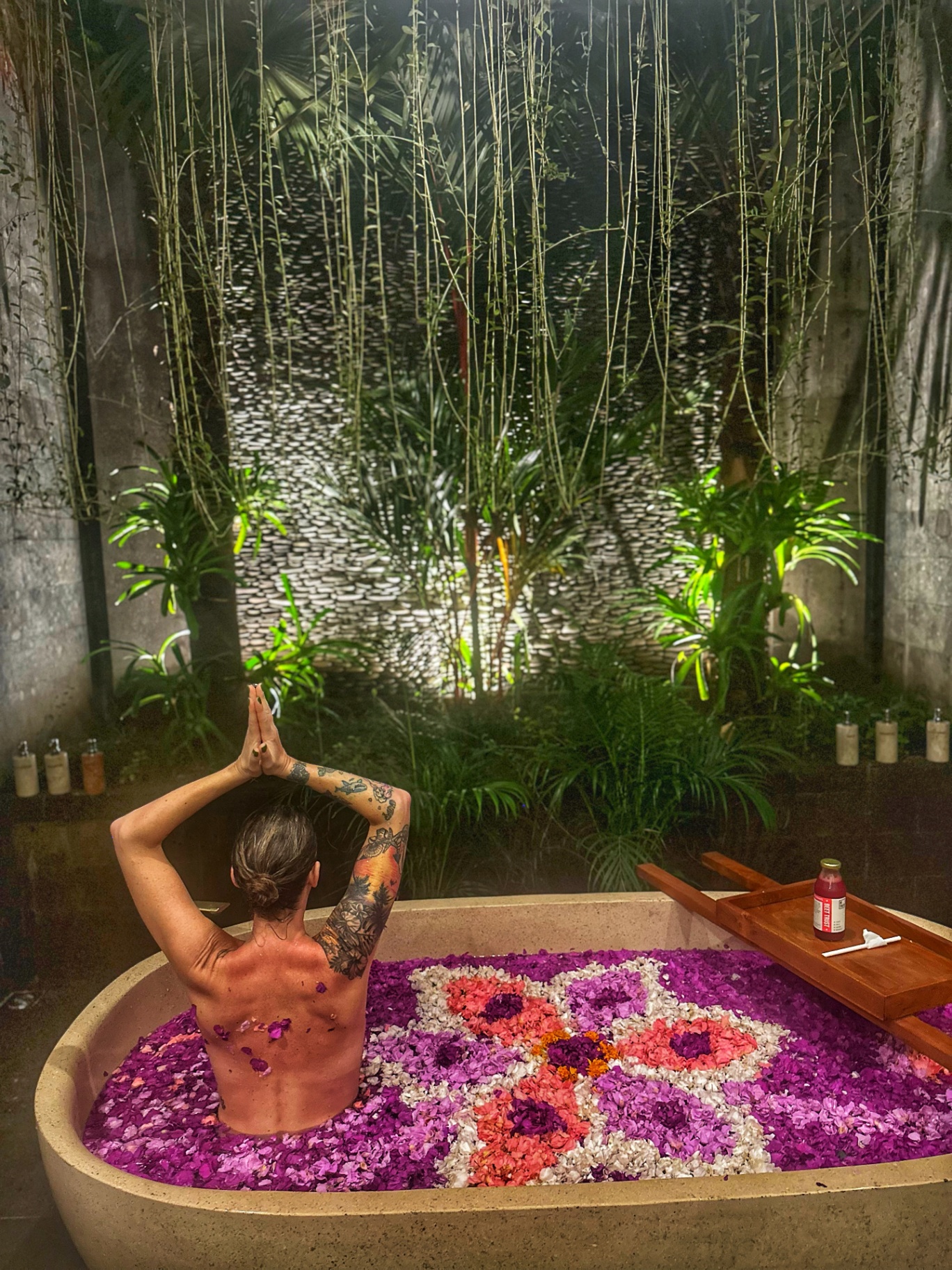 A tropical spa moment surrounded by flower petals and greenery