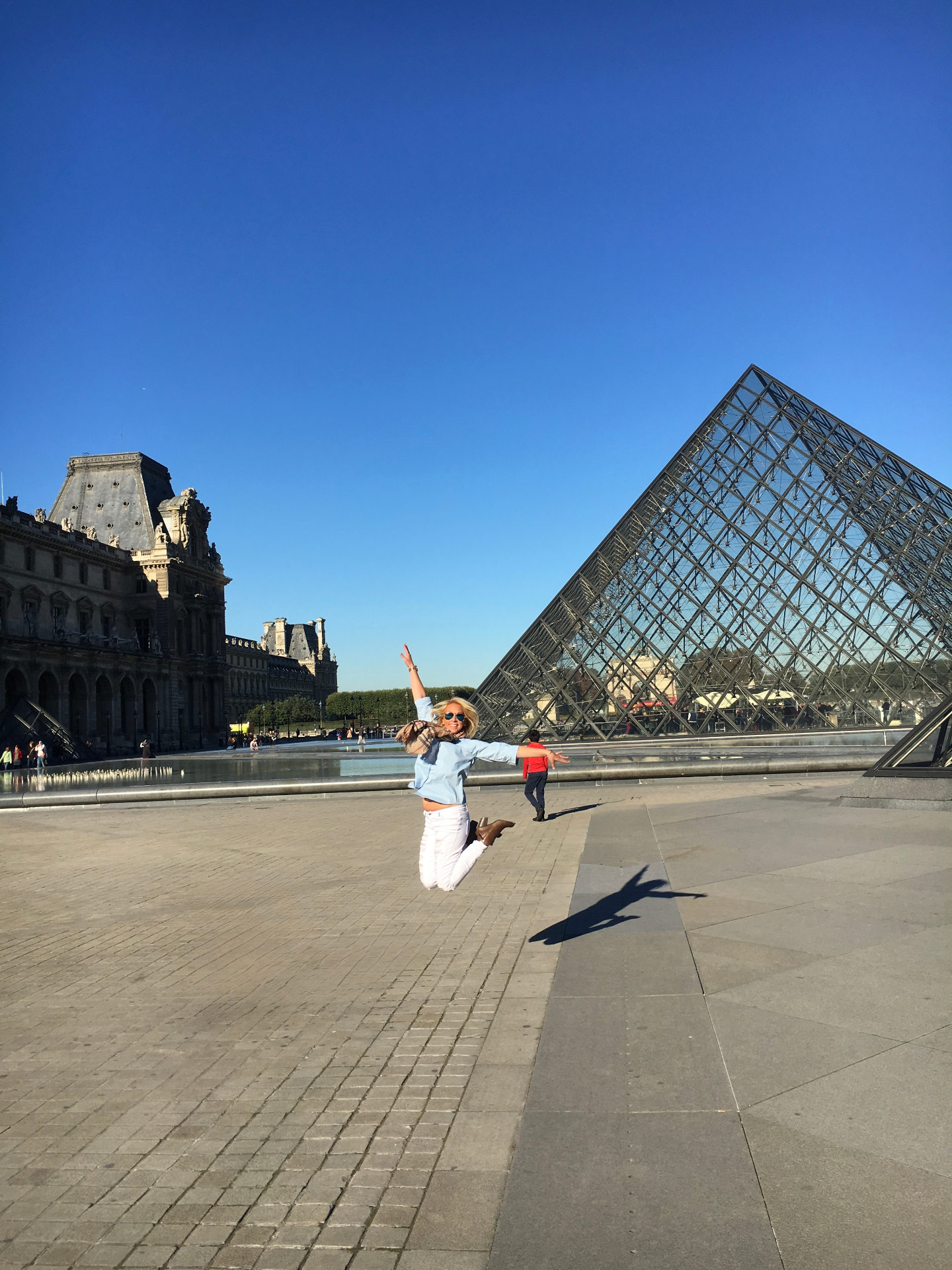 Alyssa mid-jump in front of the Louvre in Paris
